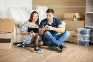Young beautiful couple sitting on floor in their new flat
